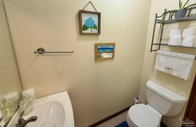 bathroom with tile patterned flooring, sink, and toilet