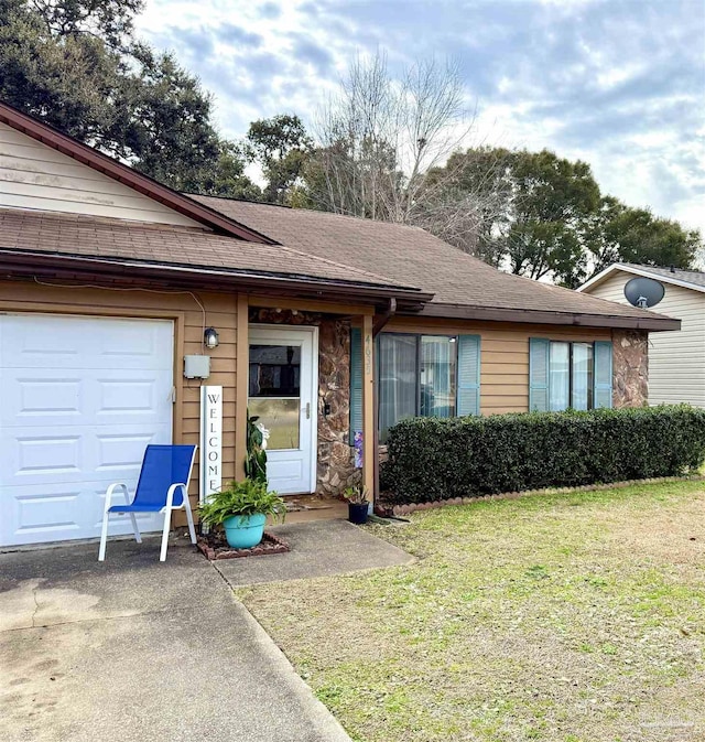 single story home with a garage and a front lawn