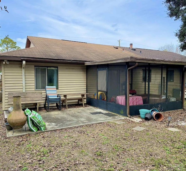 back of property with a sunroom and a patio