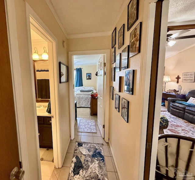 hallway with crown molding and light tile patterned flooring