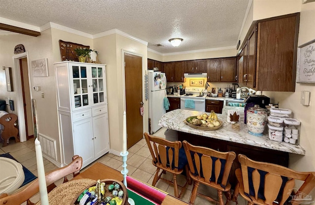 kitchen featuring light tile patterned floors, white appliances, sink, dark brown cabinetry, and a textured ceiling