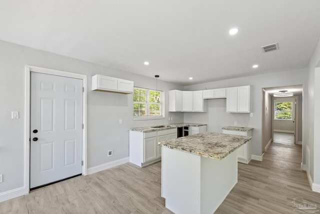 1029 Kearny Dr, Pensacola, FL 32505 - kitchen with visible vents, white cabinets, a kitchen island, and baseboards