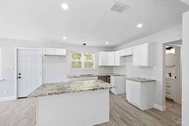 1029 Kearny Dr, Pensacola, FL 32505 - kitchen featuring a center island, light stone countertops, visible vents, and white cabinetry
