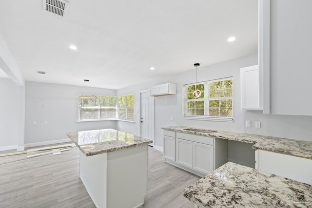 1029 Kearny Dr, Pensacola, FL 32505 - kitchen with light stone counters, visible vents, and white cabinetry