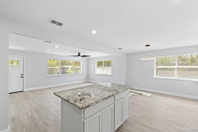 1029 Kearny Dr, Pensacola, FL 32505 - kitchen with light wood finished floors, visible vents, open floor plan, and baseboards