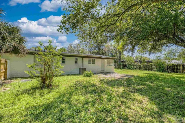 1029 Kearny Dr, Pensacola, FL 32505 - rear view of house with fence, central AC unit, and a lawn