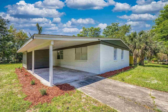 1029 Kearny Dr, Pensacola, FL 32505 - view of front of house featuring driveway, a carport, brick siding, and a front lawn