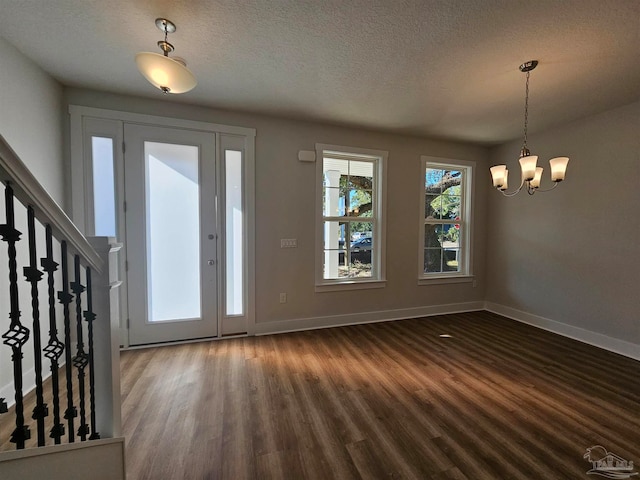 entrance foyer featuring baseboards, stairs, a chandelier, and dark wood finished floors