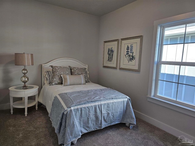 bedroom with baseboards and dark colored carpet