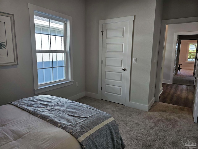 bedroom featuring baseboards and dark colored carpet