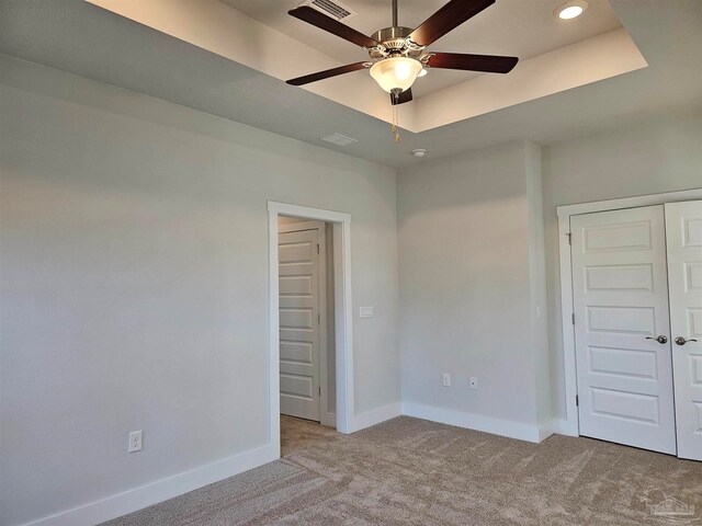 unfurnished room with recessed lighting, a raised ceiling, light colored carpet, a ceiling fan, and baseboards