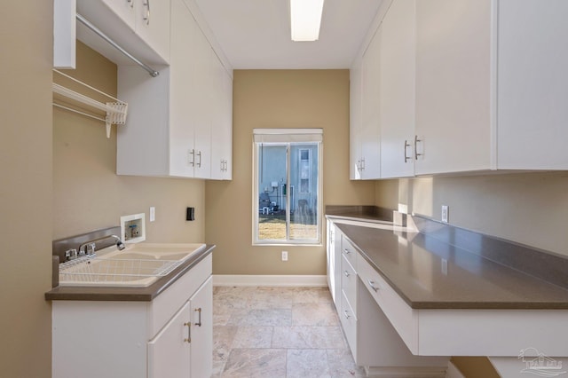 kitchen featuring white cabinets and sink