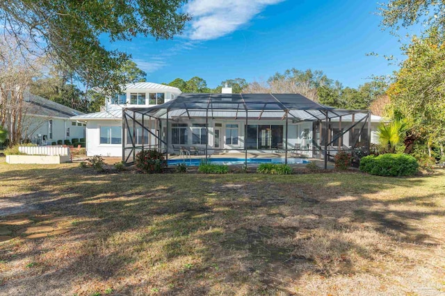 back of property with a lanai and a lawn