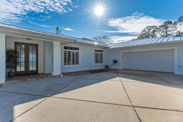 exterior space with french doors and a garage