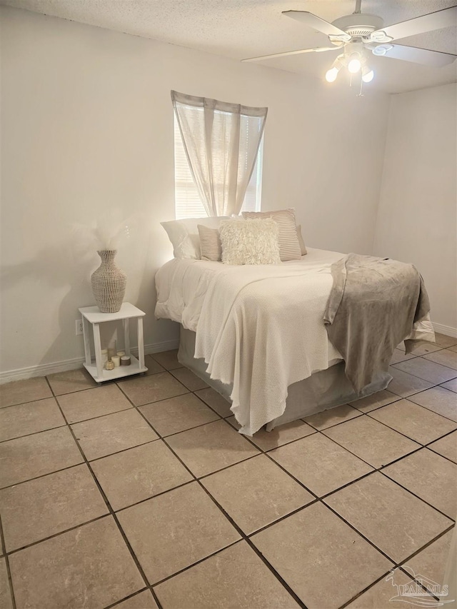 tiled bedroom featuring a textured ceiling and ceiling fan