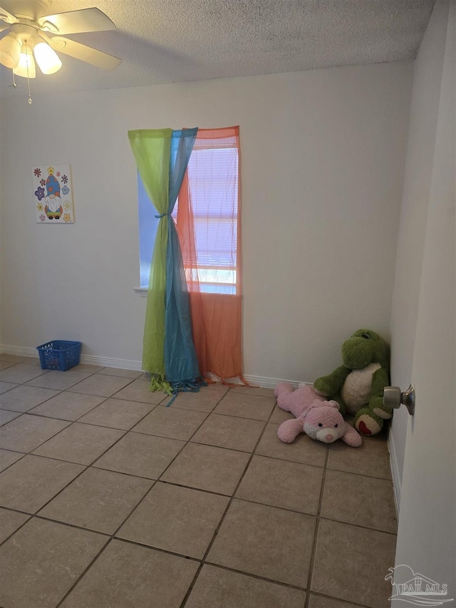 tiled spare room featuring ceiling fan and a textured ceiling