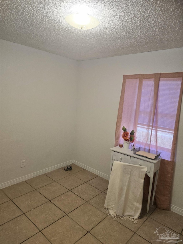 tiled spare room with a textured ceiling