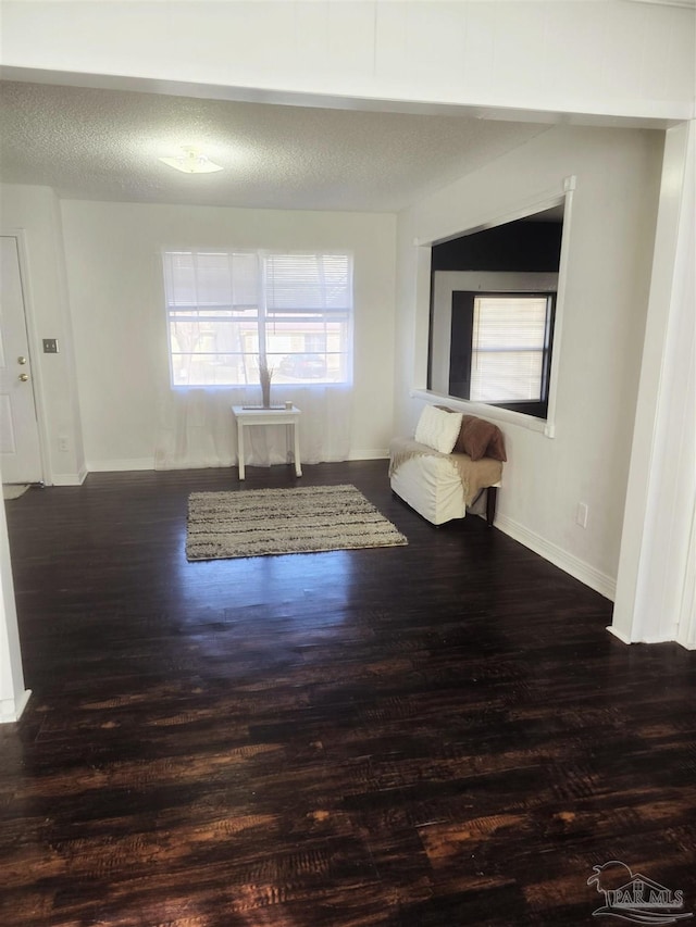 unfurnished room with dark hardwood / wood-style floors and a textured ceiling