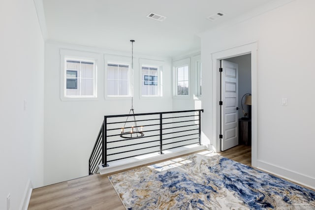 bedroom with light hardwood / wood-style floors, crown molding, and a chandelier