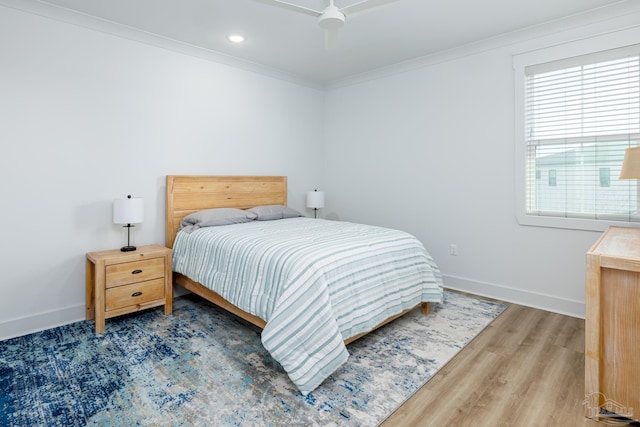 bedroom featuring hardwood / wood-style floors, ceiling fan, and crown molding