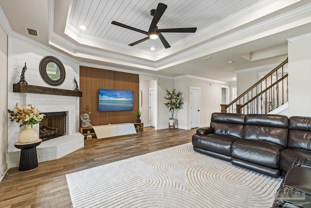 1412 Areca Palm Dr, Gulf Breeze, FL 32563 - living area with a tray ceiling, a ceiling fan, wood finished floors, a fireplace, and ornamental molding