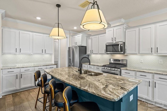 1412 Areca Palm Dr, Gulf Breeze, FL 32563 - kitchen featuring stainless steel appliances, ornamental molding, a kitchen breakfast bar, decorative backsplash, and wood finished floors