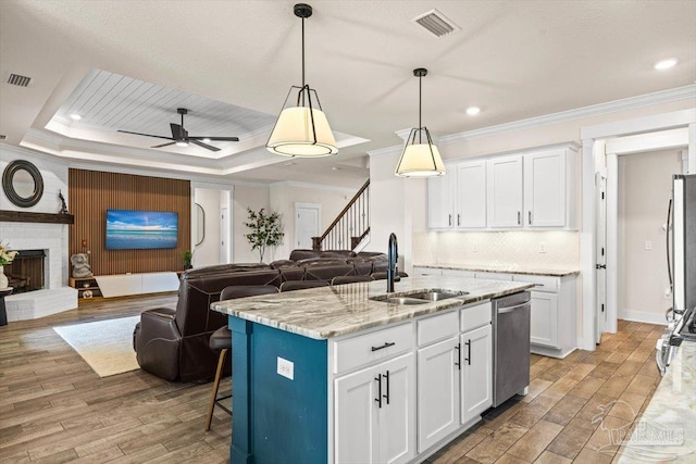 1412 Areca Palm Dr, Gulf Breeze, FL 32563 - kitchen with open floor plan, crown molding, stainless steel dishwasher, light wood finished floors, and white cabinetry