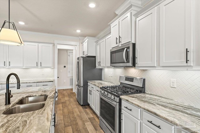 1412 Areca Palm Dr, Gulf Breeze, FL 32563 - kitchen featuring appliances with stainless steel finishes, crown molding, white cabinets, decorative backsplash, and dark wood finished floors