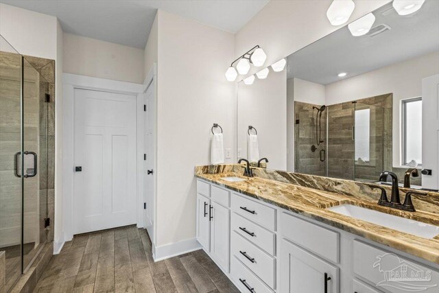 1412 Areca Palm Dr, Gulf Breeze, FL 32563 - bathroom with double vanity, a shower stall, and wood finished floors
