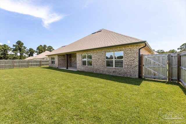 1412 Areca Palm Dr, Gulf Breeze, FL 32563 - rear view of house featuring a fenced backyard, brick siding, a gate, and roof with shingles
