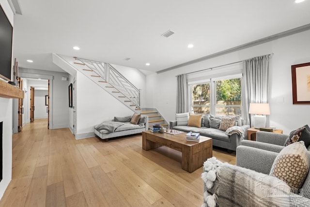 living room with light hardwood / wood-style floors and crown molding