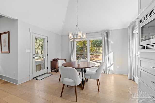 dining room with a notable chandelier, plenty of natural light, and light hardwood / wood-style floors