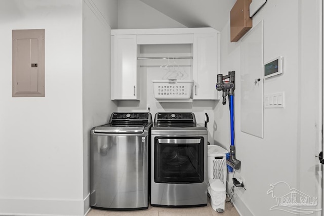 clothes washing area featuring washer and clothes dryer, cabinets, light tile patterned floors, and electric panel