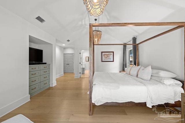 bedroom with light hardwood / wood-style floors and lofted ceiling