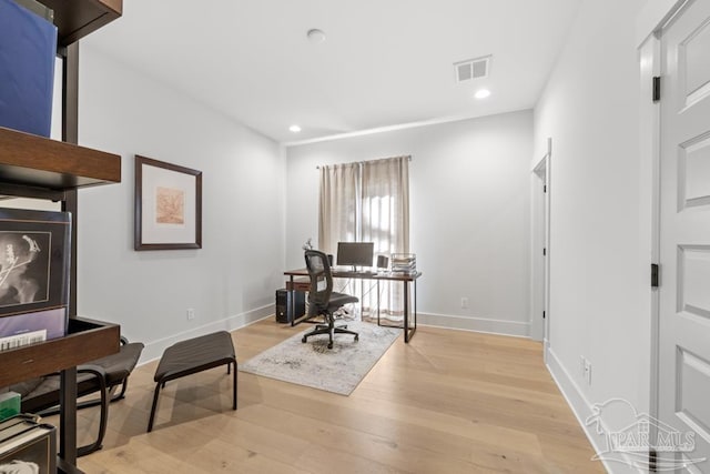 home office with light hardwood / wood-style floors