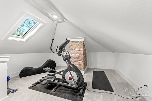 exercise room with lofted ceiling with skylight and carpet floors