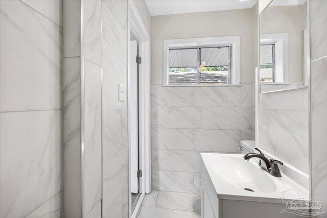 bathroom with vanity and tile walls