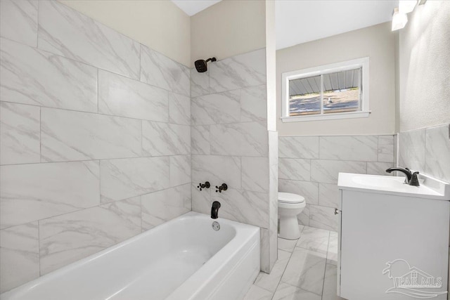 full bathroom featuring vanity, tiled shower / bath, tile walls, and toilet