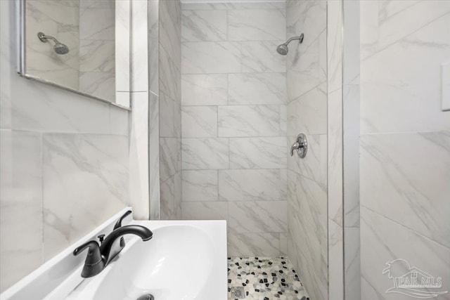 bathroom with sink and a tile shower