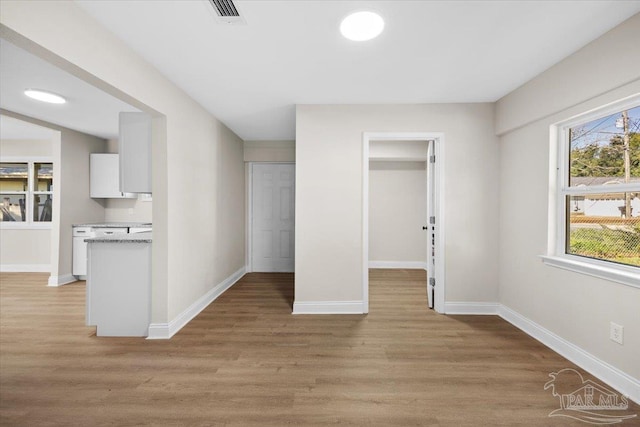 unfurnished bedroom featuring a walk in closet and light hardwood / wood-style flooring