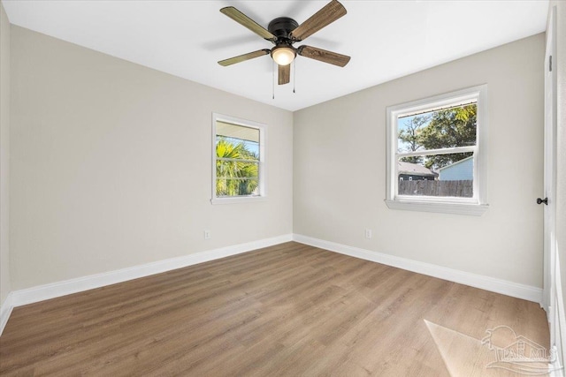 empty room featuring ceiling fan, plenty of natural light, and light hardwood / wood-style floors