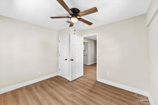 unfurnished bedroom featuring ceiling fan, light wood-type flooring, and a closet