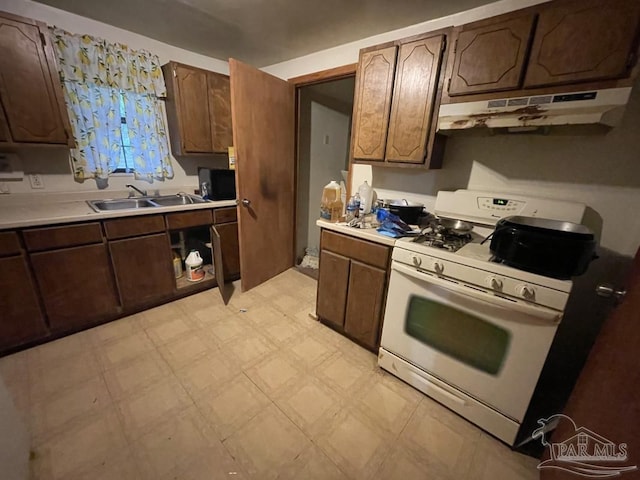 1500 N Hayne St, Pensacola, FL 32503 - kitchen featuring white gas stove, under cabinet range hood, a sink, light floors, and light countertops