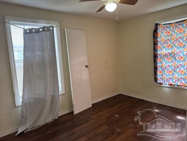 empty room with ceiling fan, baseboards, and wood finished floors