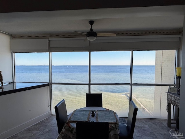 sunroom featuring a water view and ceiling fan