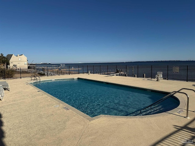 view of pool with a water view and a patio area