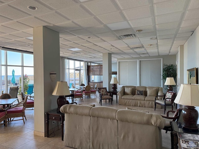 tiled living room with a paneled ceiling and a water view