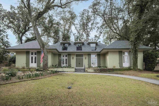 view of front of home featuring a shingled roof, a front yard, french doors, and stucco siding