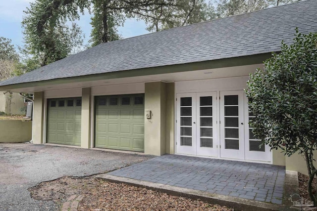 garage with aphalt driveway and french doors