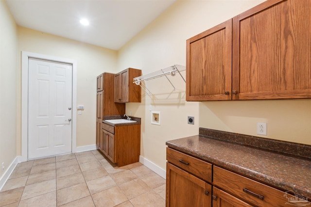 laundry room with hookup for a washing machine, sink, light tile patterned flooring, electric dryer hookup, and cabinets